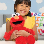Child holding a red plush toy with googly eyes in a colorful room