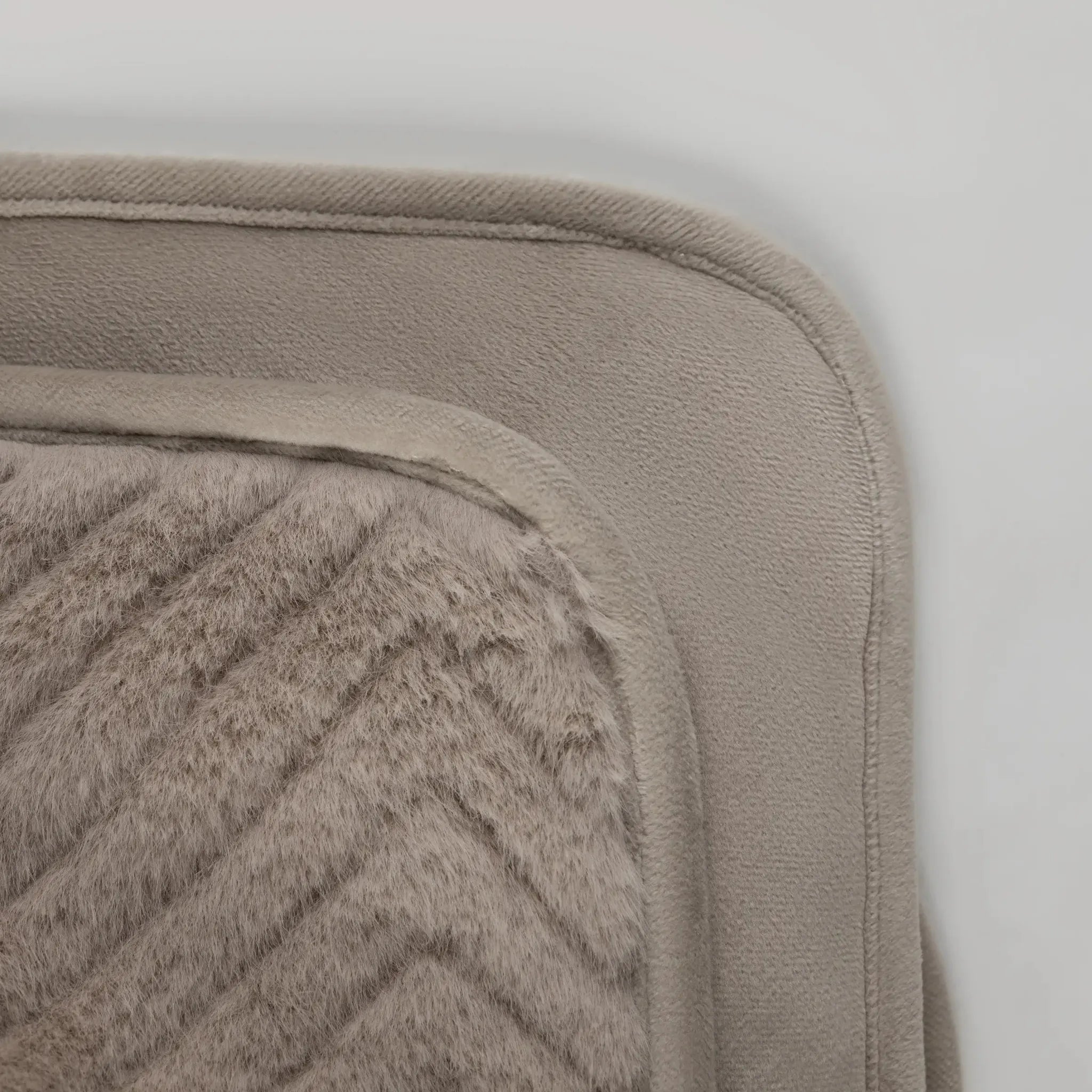 Close-up of Ellis Throw in Minkshowing a textured chevron pattern and a smooth, stitched border in a warm taupe color.