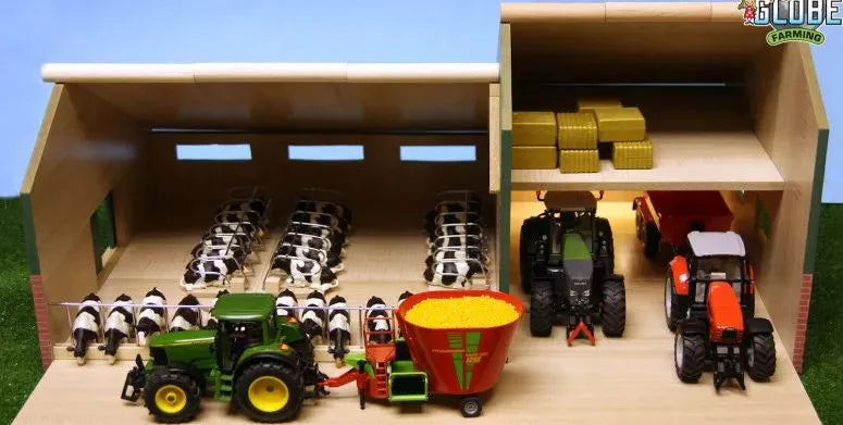 Toy farm set with tractors and equipment inside a model barn.