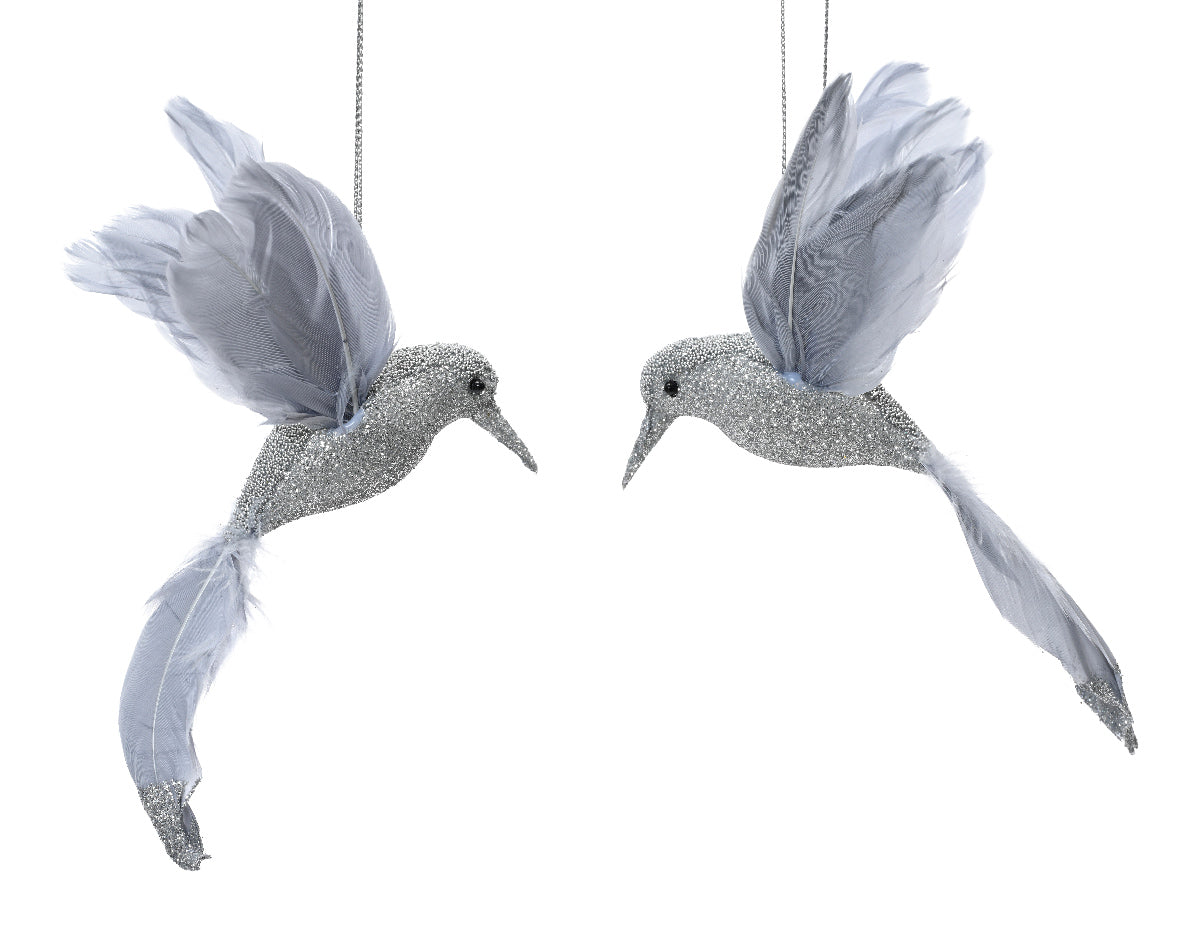 Two decorative hummingbirds with glittery feathers on a white background