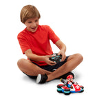 Child playing with a toy RC car and figure on a white background