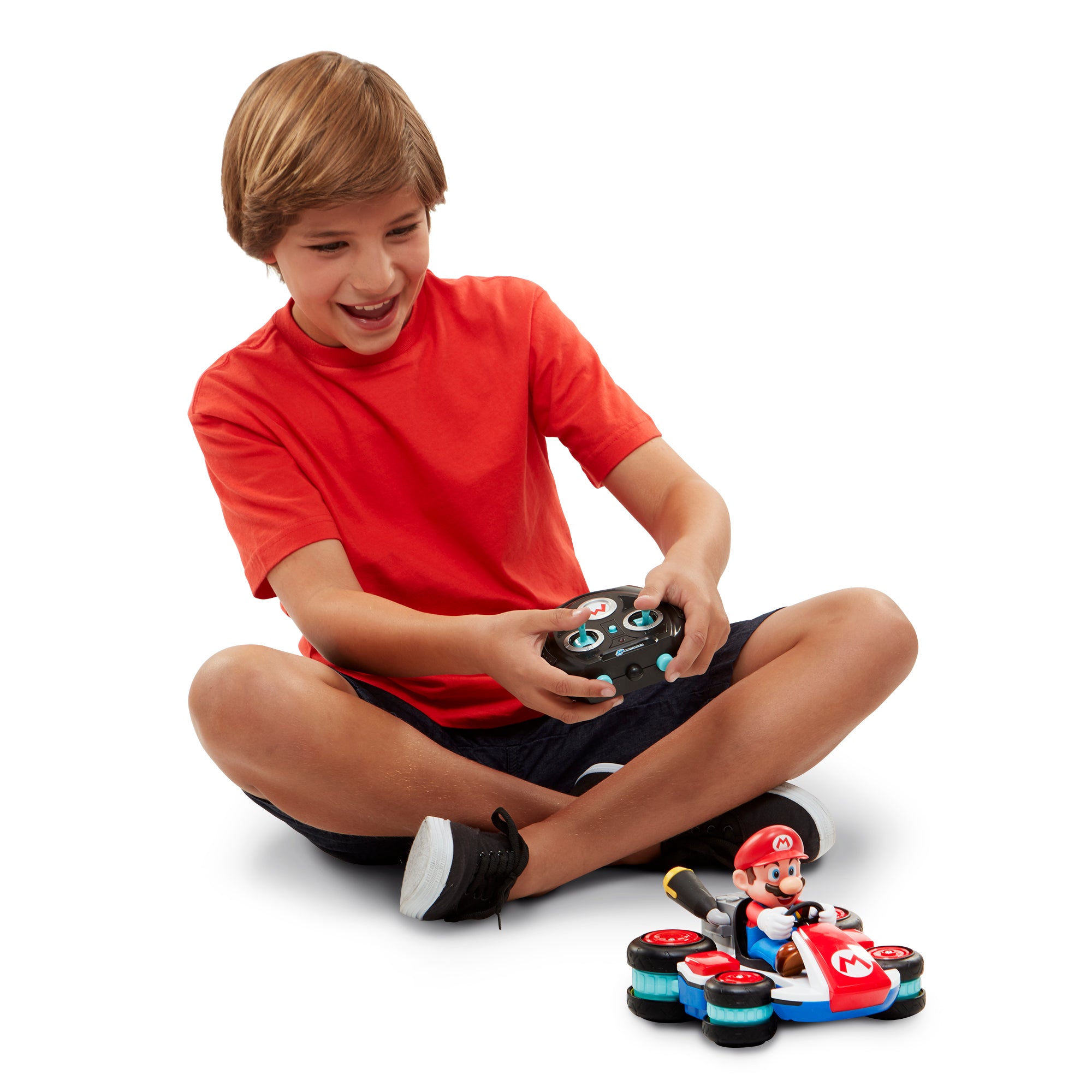 Child playing with a toy RC car and figure on a white background