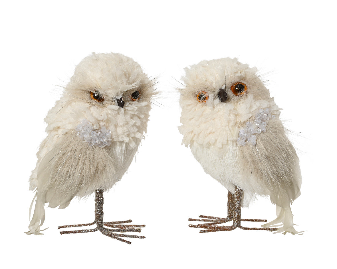 Two decorative owls with fluffy white feathers and orange eyes on a white background