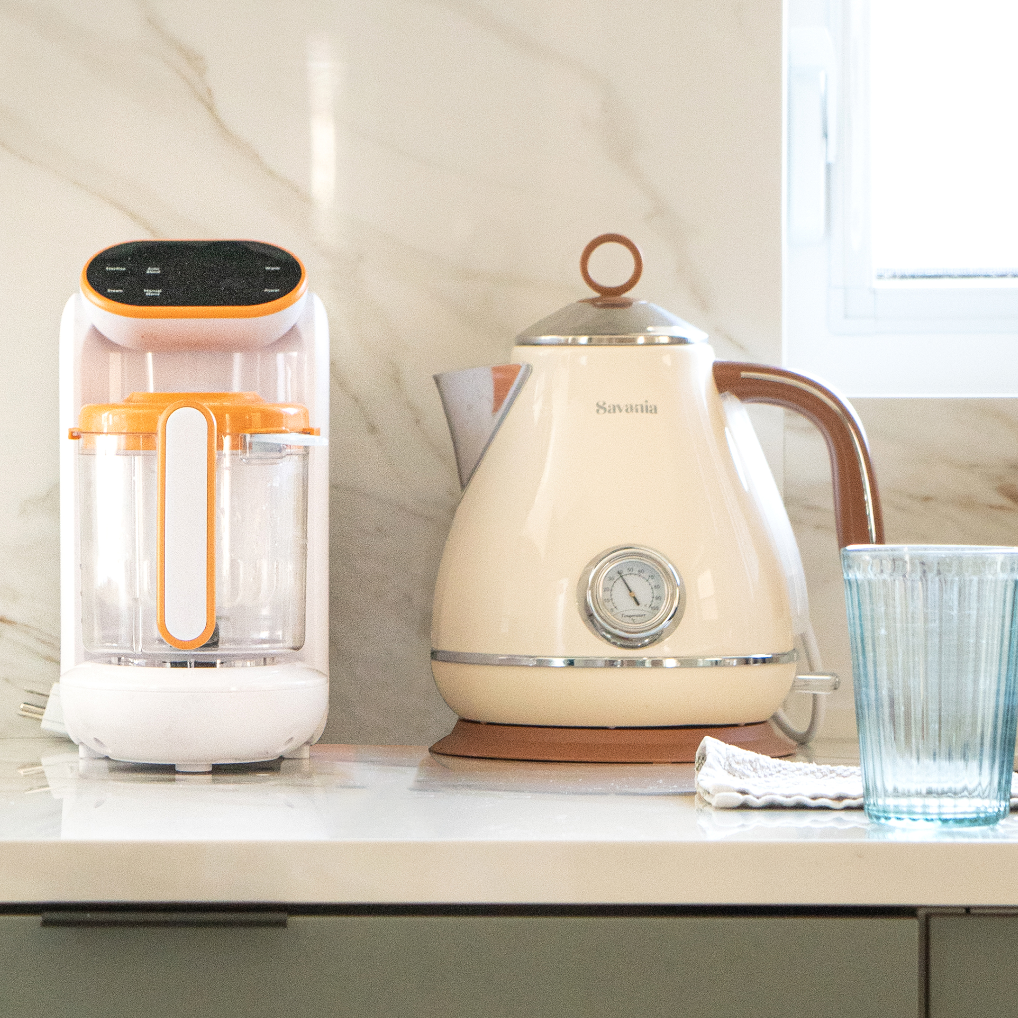 Two kitchen appliances on a countertop with a glass of water.