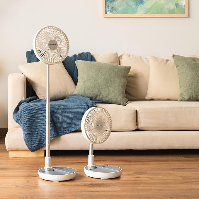 Two Cecotec EnergySilence 800 Foldable Fan in White  on a wooden floor with a beige sofa and decorative pillows in the background.