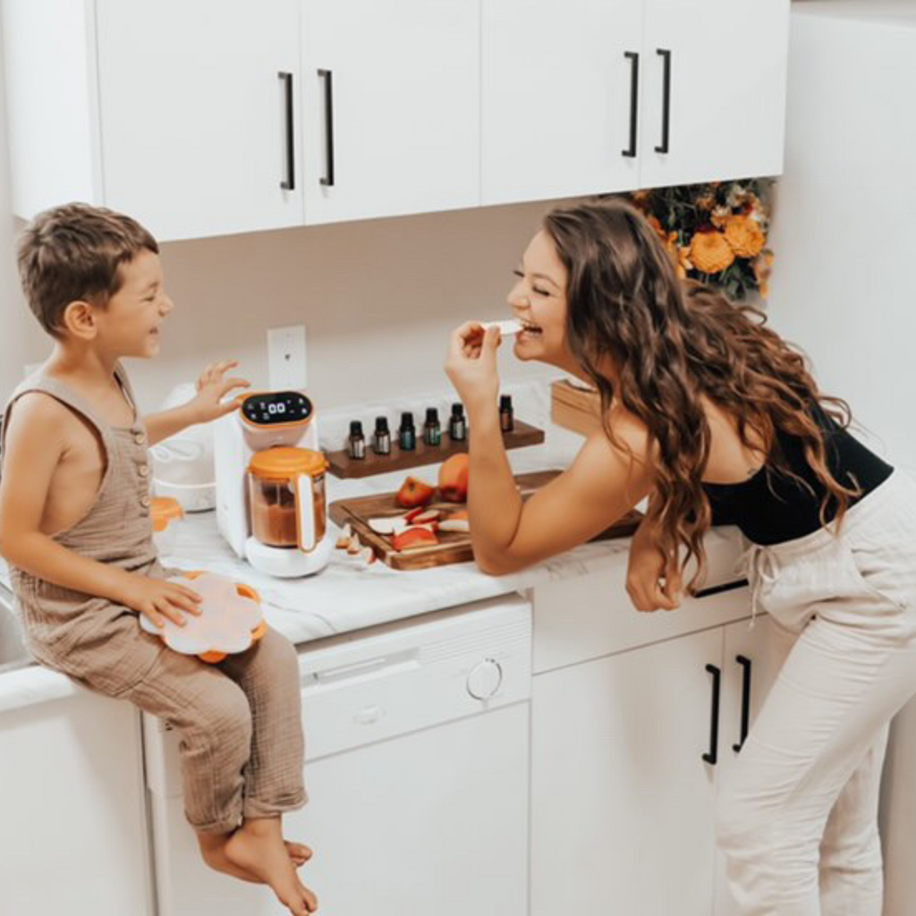 Woman and child in a kitchen with white cabinets and a white countertop.