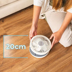 Person holding a small Cecotec EnergySilence 800 Foldable Fan in White on a wooden floor with a measurement label indicating 20cm.