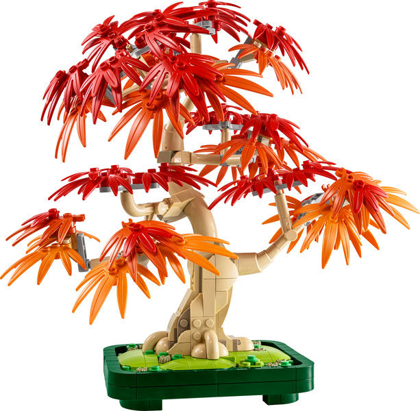 Toy bonsai tree with red leaves on a white background