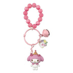 Pink keychain with a cartoon character and colorful charm on a white background