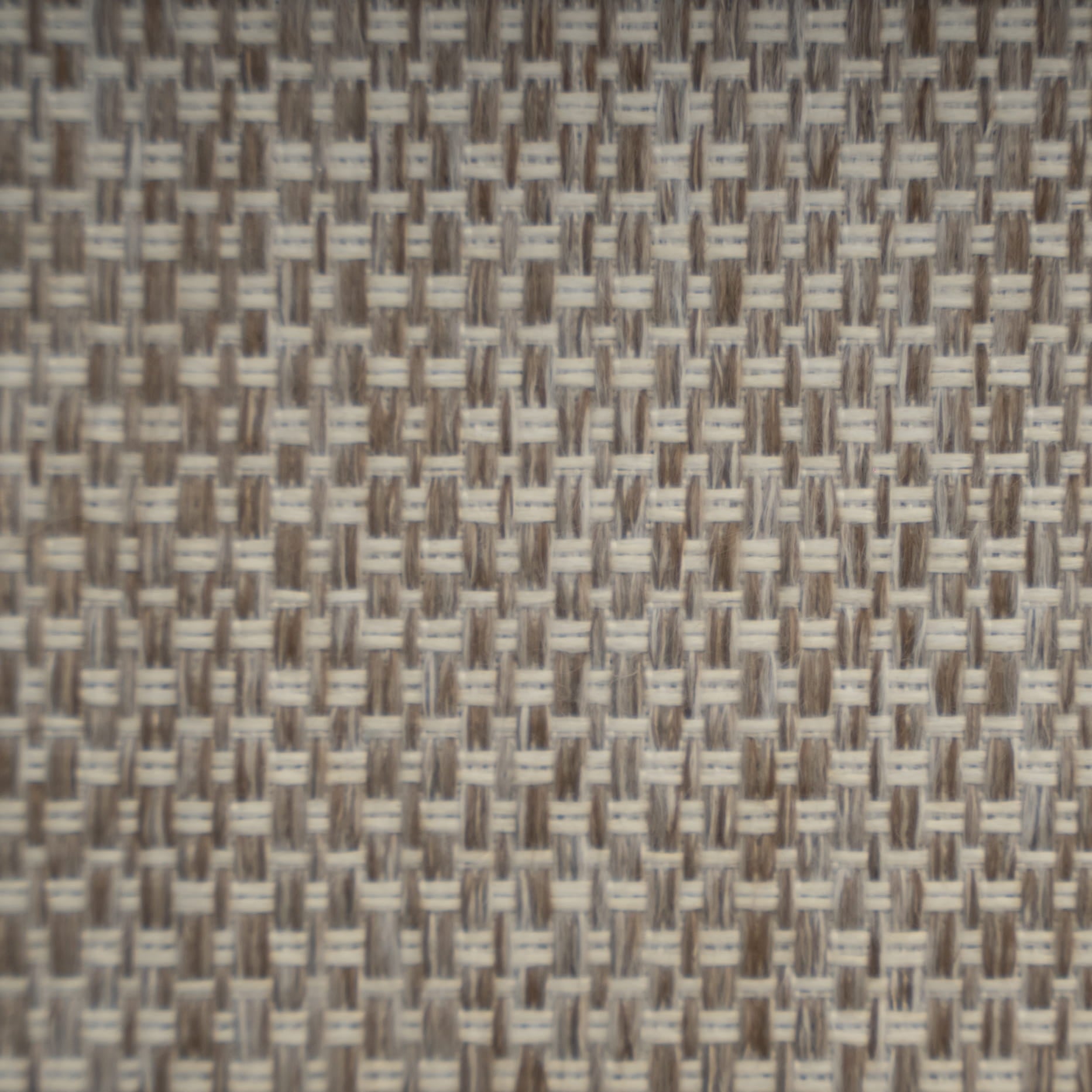 A close-up of a woven fabric or material texture with a basketweave pattern in beige, taupe, and off-white.