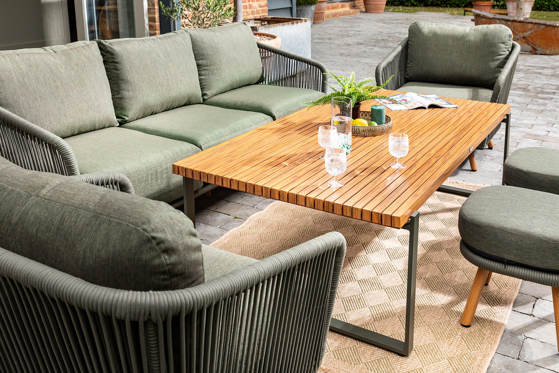 Outdoor patio furniture set with a wooden table and green cushions close up of the Eden 3 Seat Lounge Set