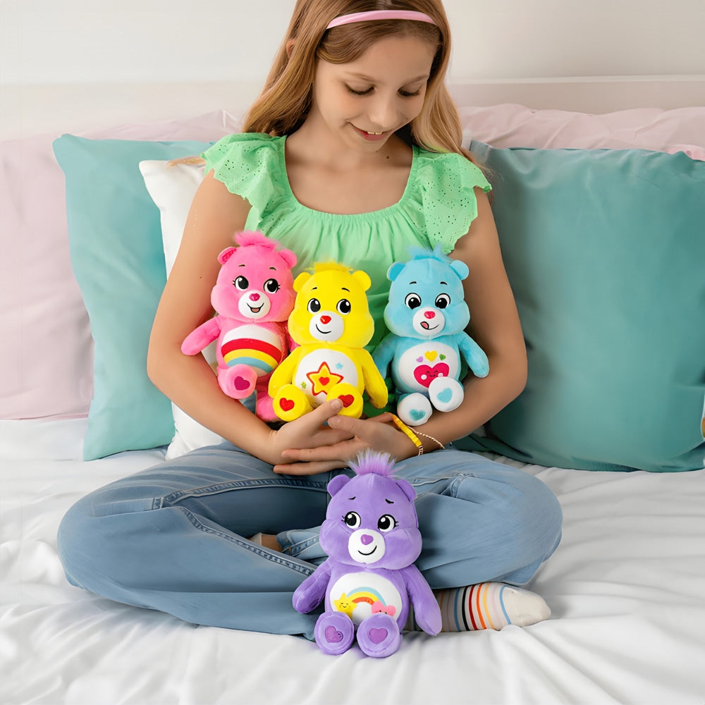 Girl holding four colorful Care Bears on a bed