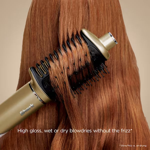 Hair dryer with brush attachment being used on long brown hair against a beige background