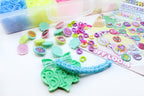 Colorful craft supplies including letters and a bracelet on a white background