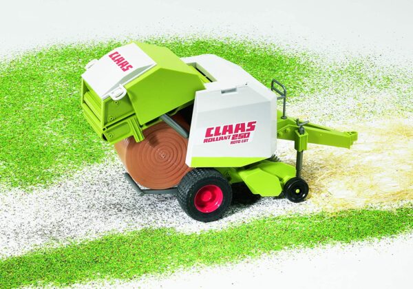 A Bruder Claas Round Baler toy, featuring a green and gray baler with a bale of hay attached, and red and black wheels and accents.