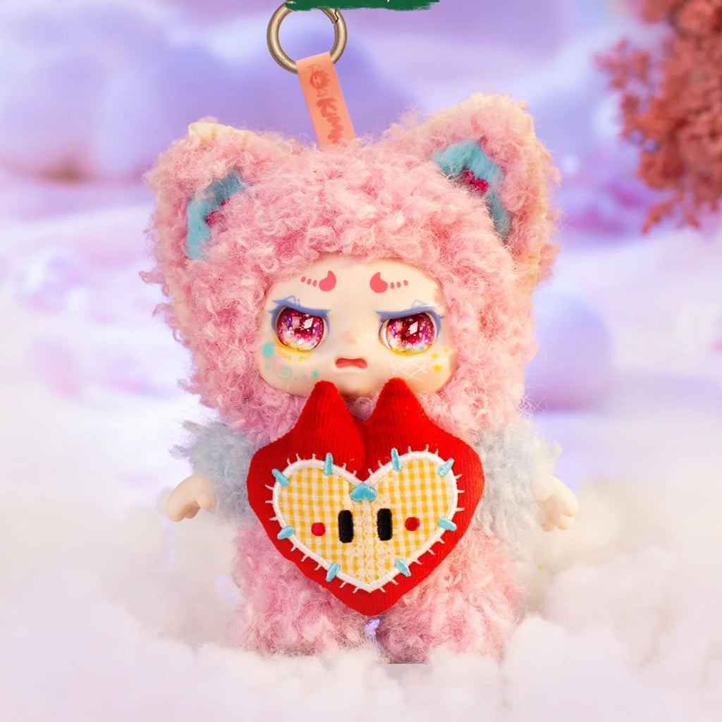 Plush toy with pink fur and a red heart, set against a soft focus background.
