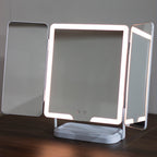 Hollywood Rechargeable Portable Mirror with LED lights on a wooden surface.
