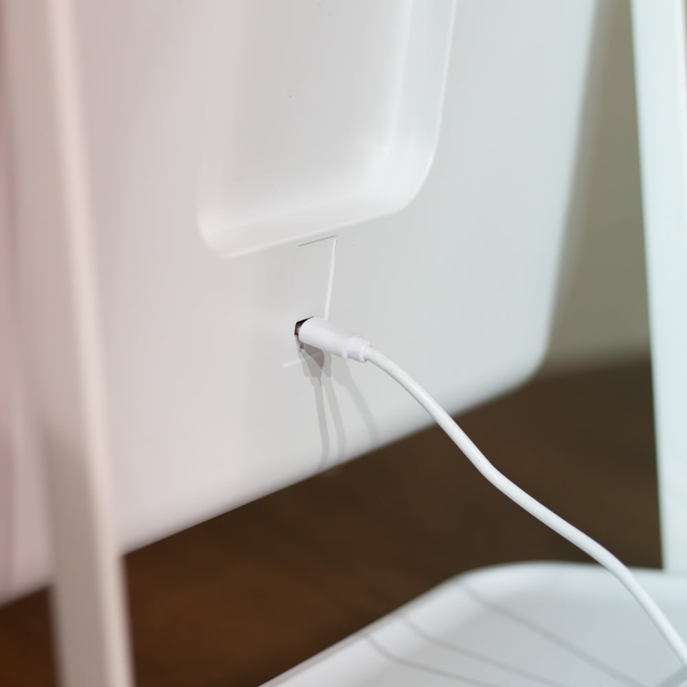 Close-up of aHollywood Rechargeable Portable Mirror with a usb attached for recharge, background view