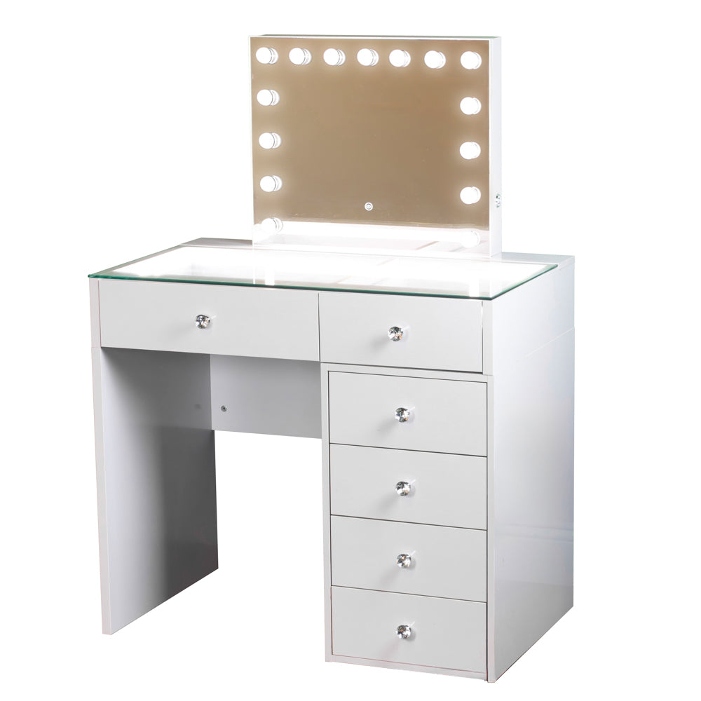 White vanity desk with glass top and mirror with light bulbs on a white background