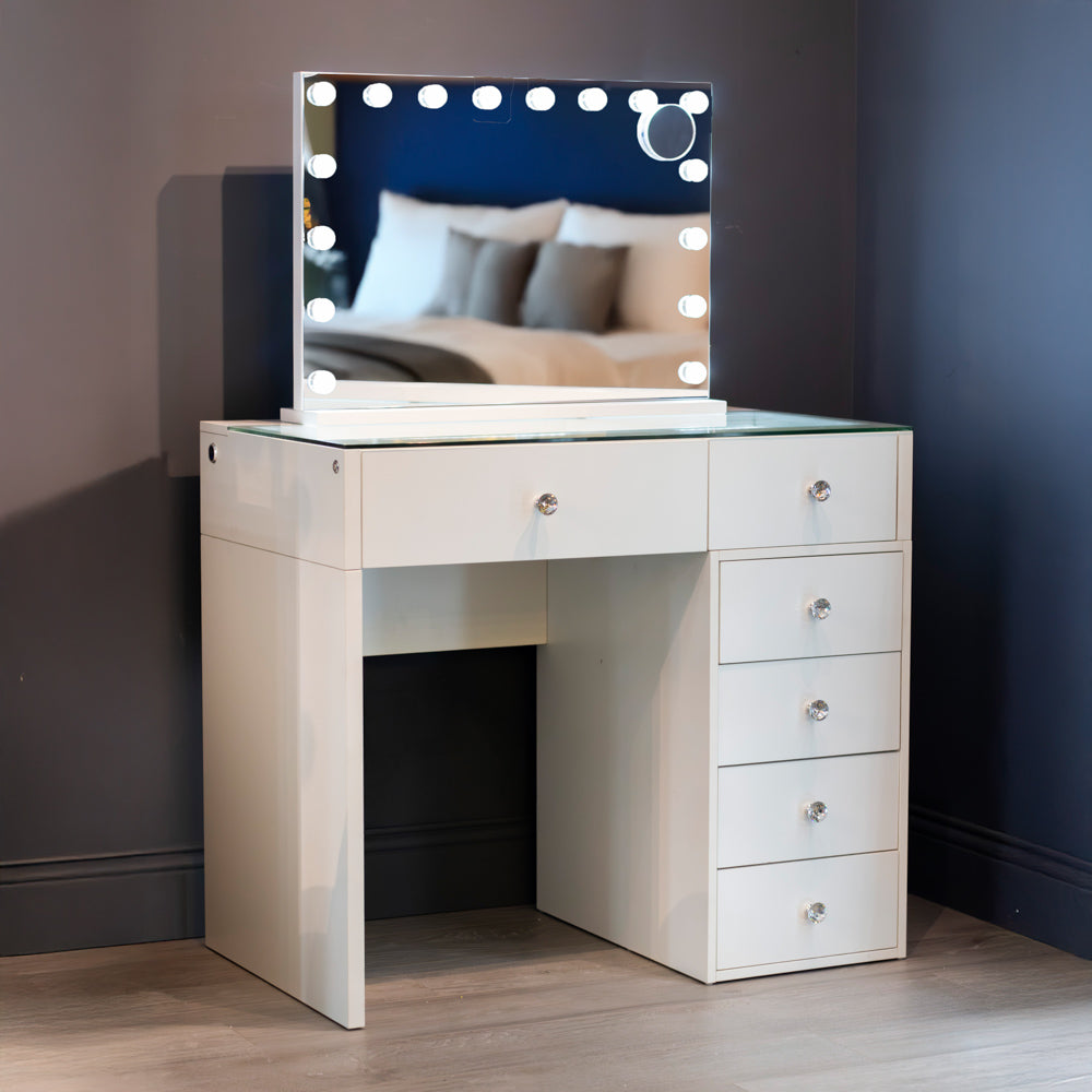 White vanity table with illuminated mirror in a room setting.