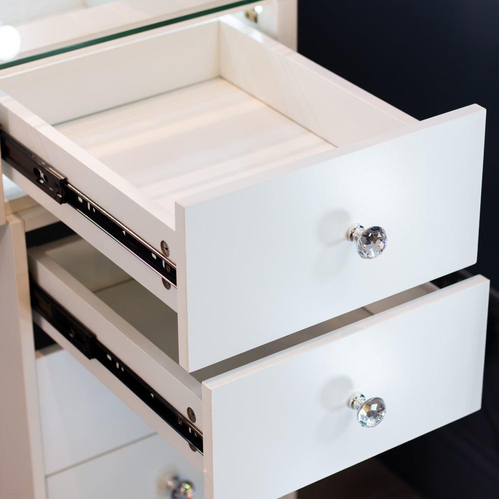 White vanity drawers with crystal-style round knobs, shown with two upper drawers open to reveal the interior storage space.