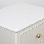 Monroe 2 Drawer Accent Table in Stone cabinet with a white countertop and gold handle.