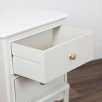 Monroe 2 Drawer Accent Table in Stonewith an open drawer showcasing a round gold pull knob, set against a light wall and dark wood floor.