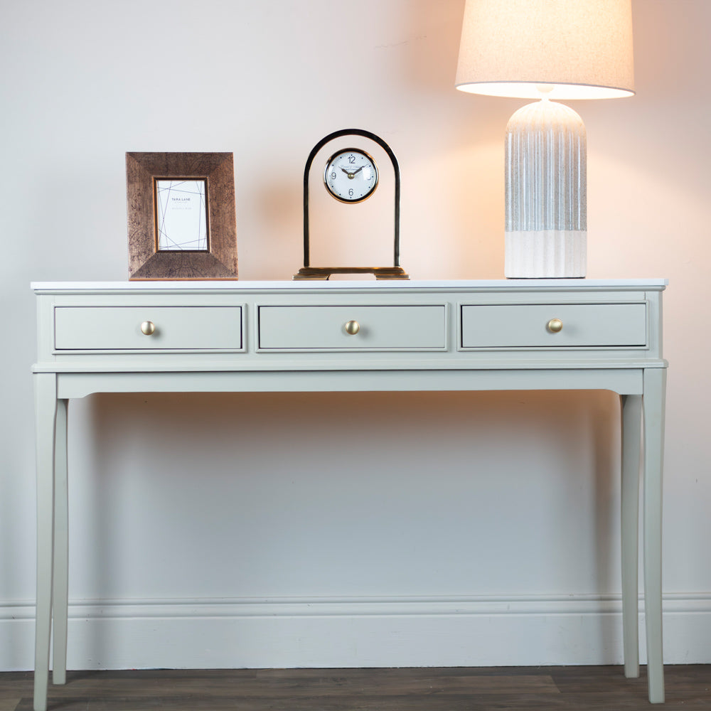 Monroe 3 Drawer Console Table in Stone  console table with decorative items against a white wall