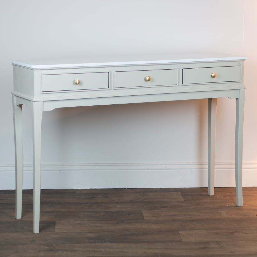 Monroe 3 Drawer Console Table in Stone with three drawers on a wooden floor against a white wall