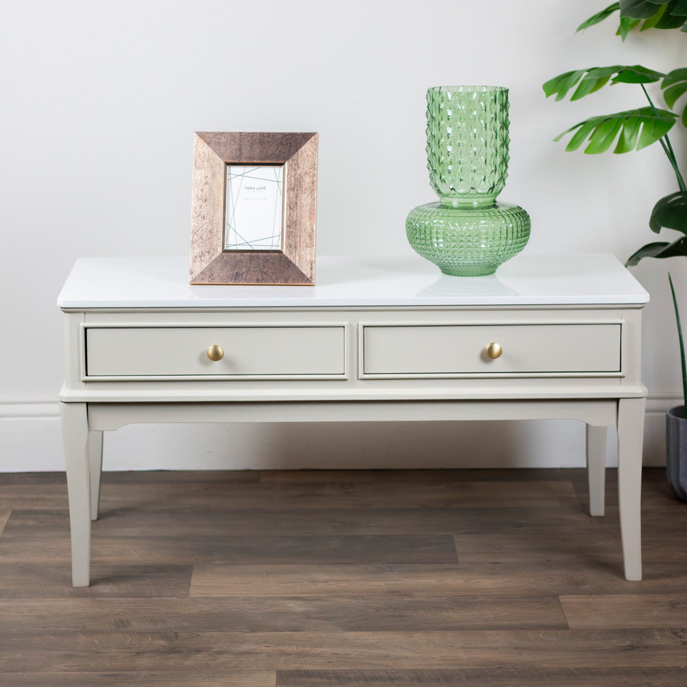 Monroe Coffee Table in Stone console table with a green vase and framed picture on a wooden floor.