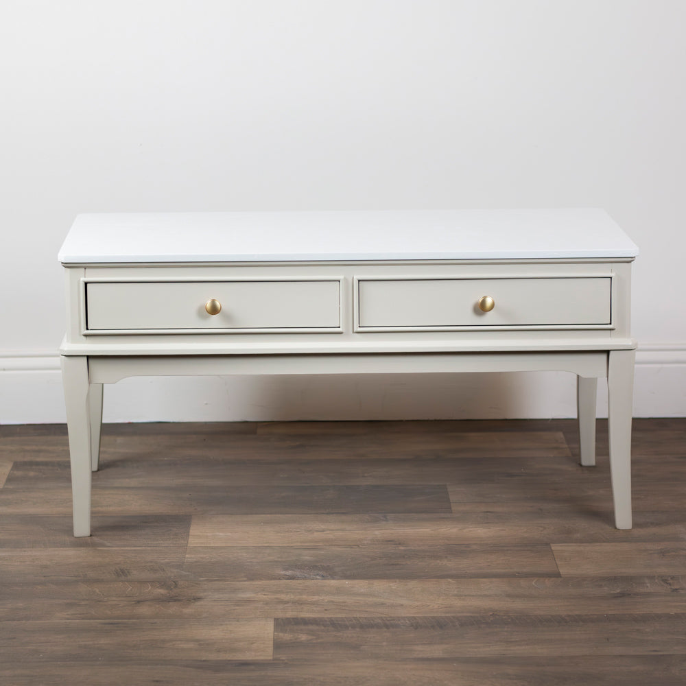 Monroe Coffee Table in Stone with two drawers on a wooden floor against a white wall