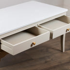 Monroe Coffee Table in Stone with two open drawers and small round gold knobs, set against a dark wood floor.