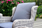 Wicker chair with gray cushion in a garden setting