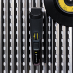 Black and yellow grooming tool on a metallic surface