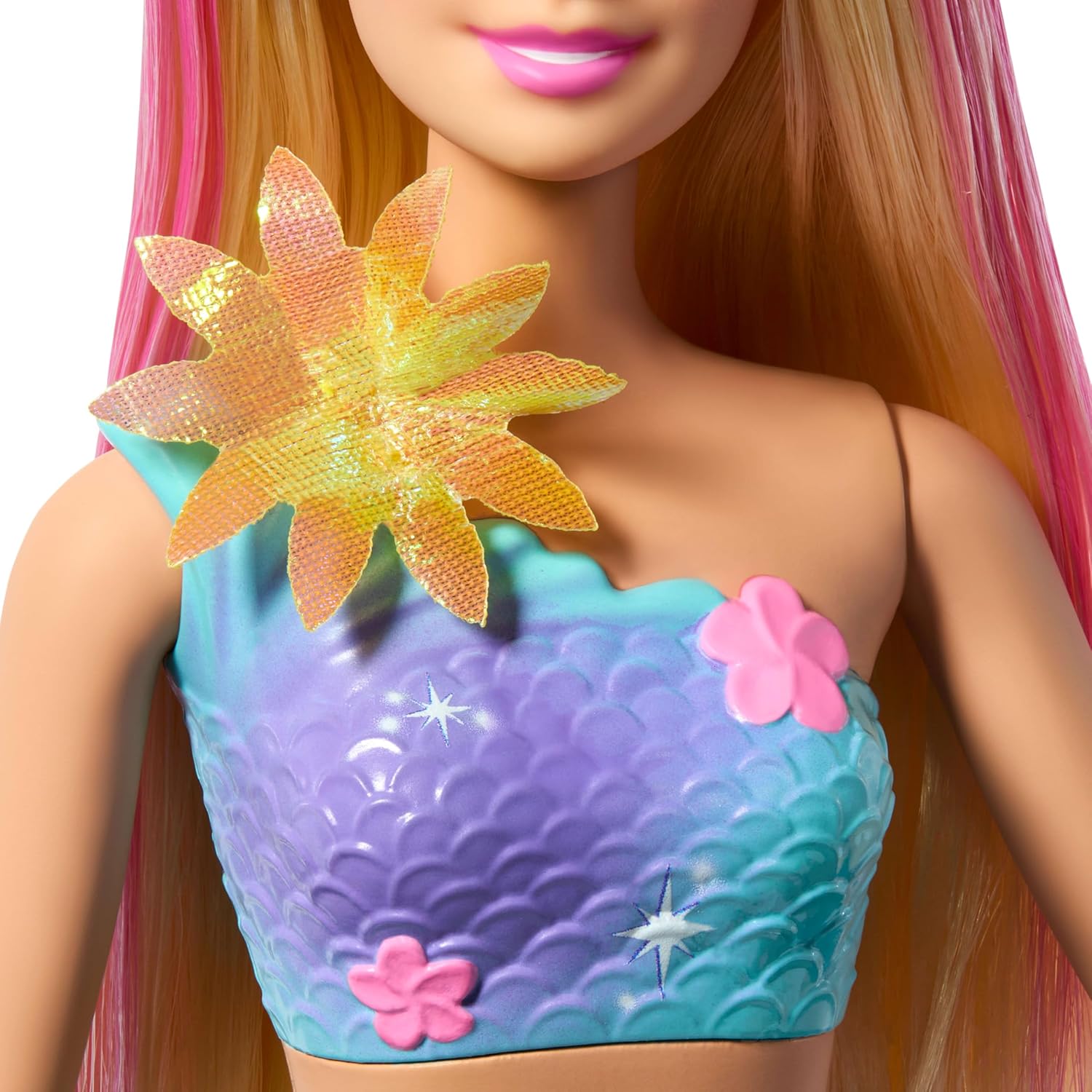 Barbie doll with a colorful top featuring flowers and scales.