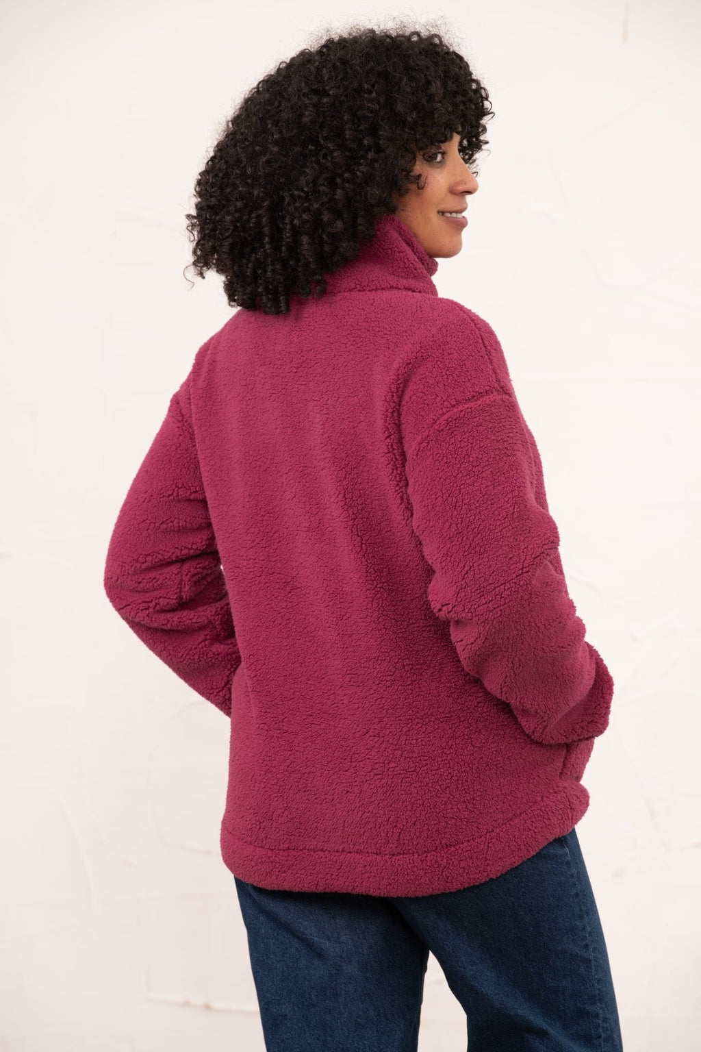 Person wearing a pink fleece jacket on a white background