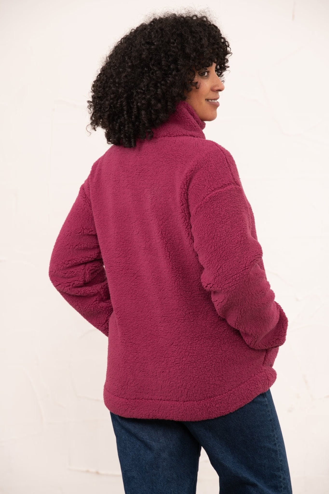 Person wearing a pink fleece jacket on a white background