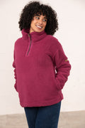Woman wearing a pink fleece pullover against a white background