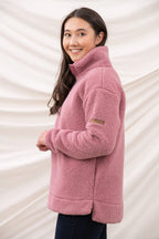 Woman wearing a pink fleece jacket against a white background