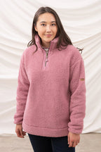 Woman wearing a pink fleece pullover against a white background