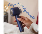 Hand holding a blue hair dryer with 'Compact and Lightweight' text on a blurred background