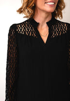 Fransa Bess blouse in black with laser‑cut chevron sleeves and frill‑trimmed V‑neck, loose hip‑length fit
