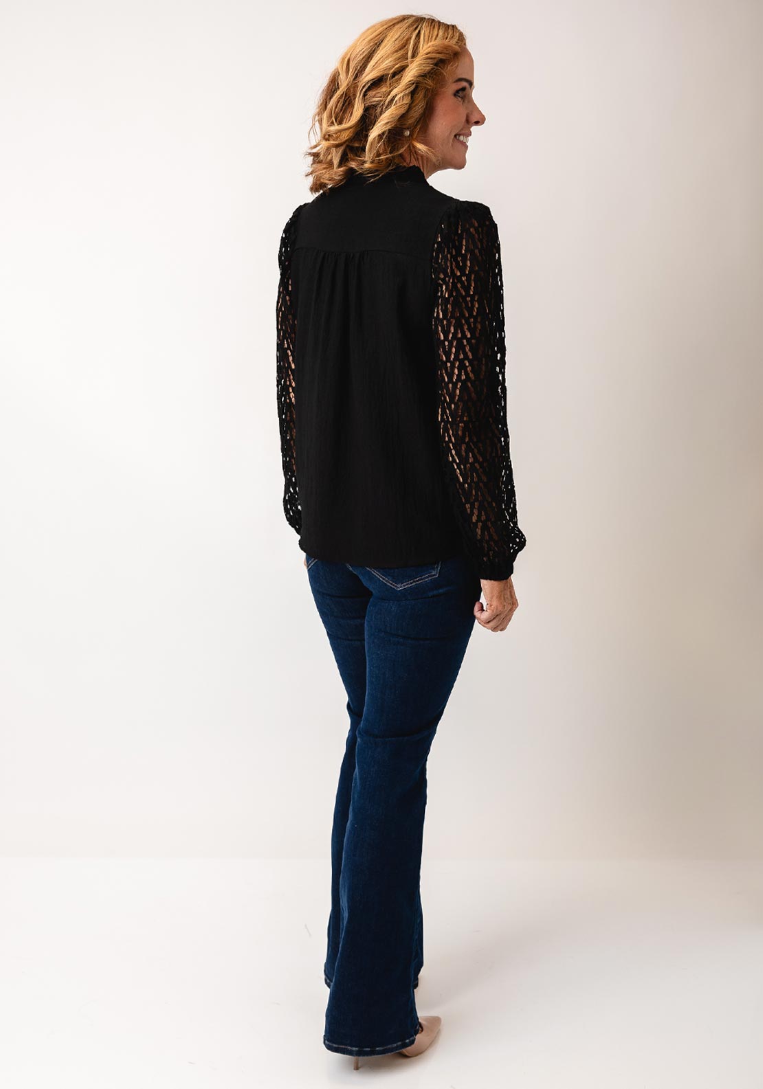 Fransa Bess blouse in black with laser‑cut chevron sleeves and frill‑trimmed V‑neck, loose hip‑length fit