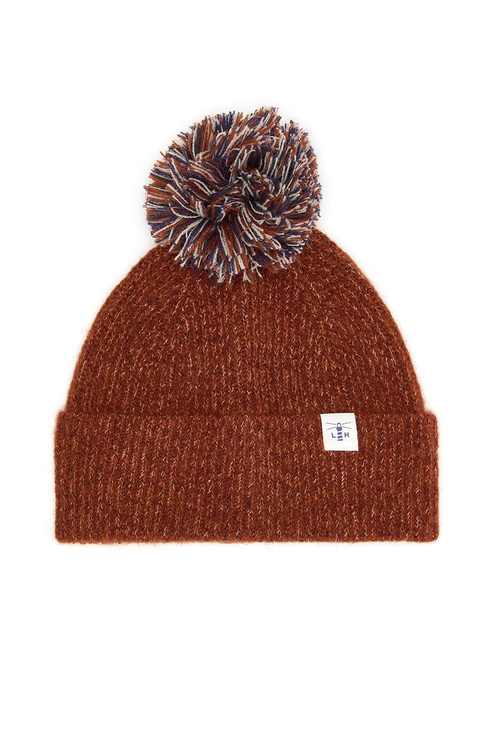 A brown ribbed knit beanie hat with a matching brown, black, and white pom-pom on top, featuring a small white brand tag on the side cuff.