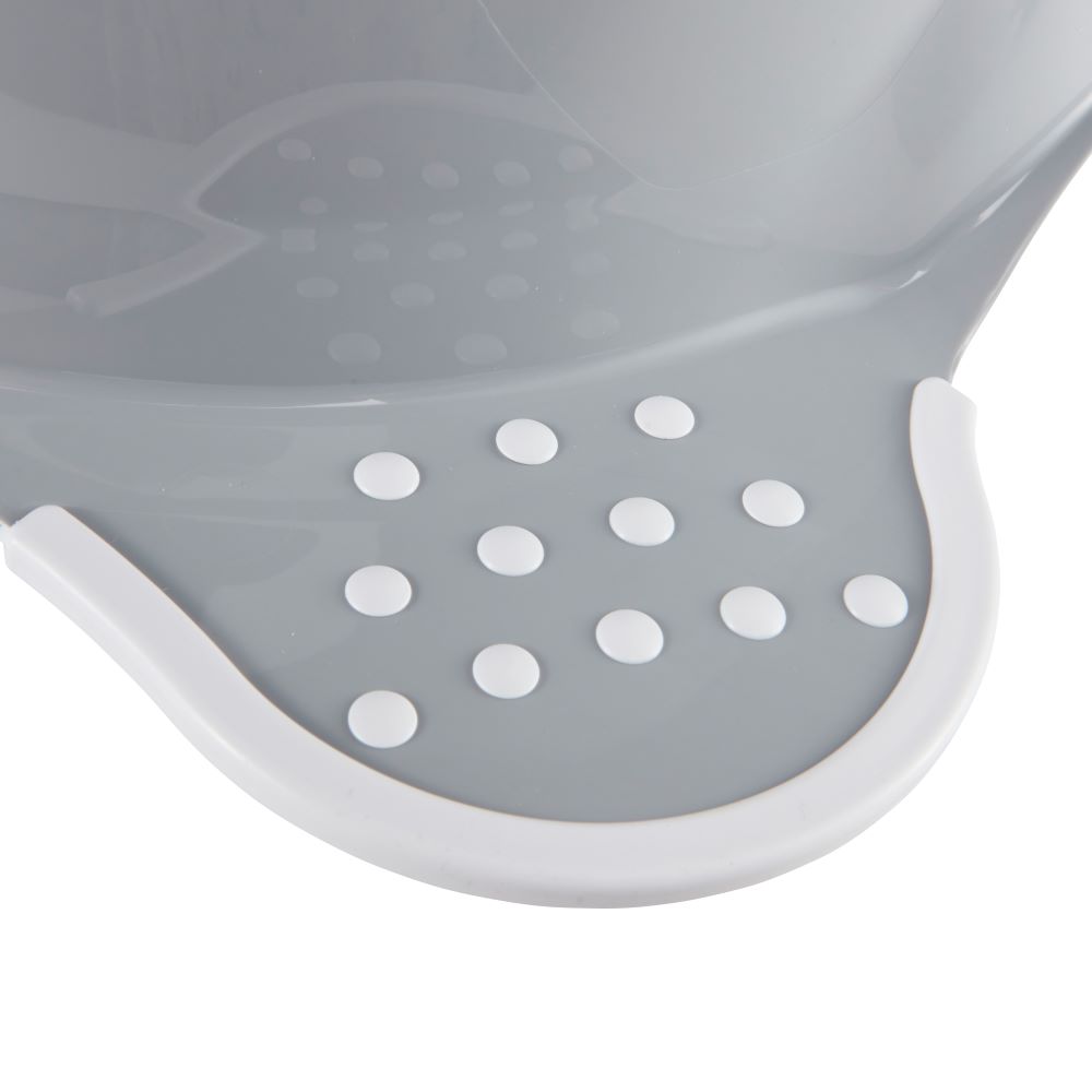 Close-up of a gray plastic foot potty seat with a white curved rim and multiple circular drainage holes, shown on a white background.