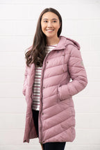 Woman wearing a pink quilted jacket against a white background