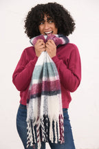 Woman wearing a colorful plaid scarf with a white background
