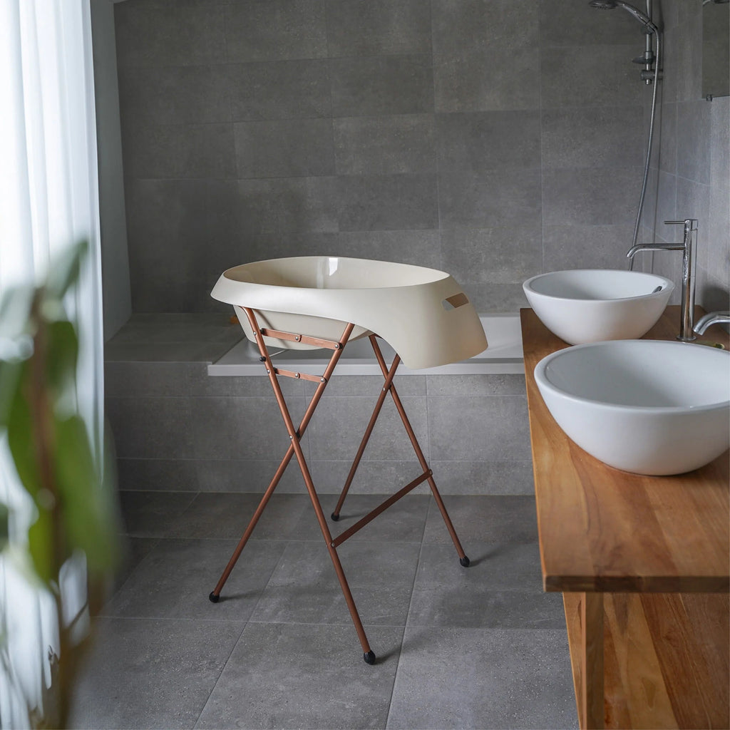 Bathroom with freestanding bathtub, wooden vanity, and white sinks.