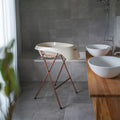 Bathroom with freestanding bathtub, wooden vanity, and white sinks.