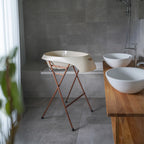 Bathroom with freestanding bathtub, wooden vanity, and white sinks.